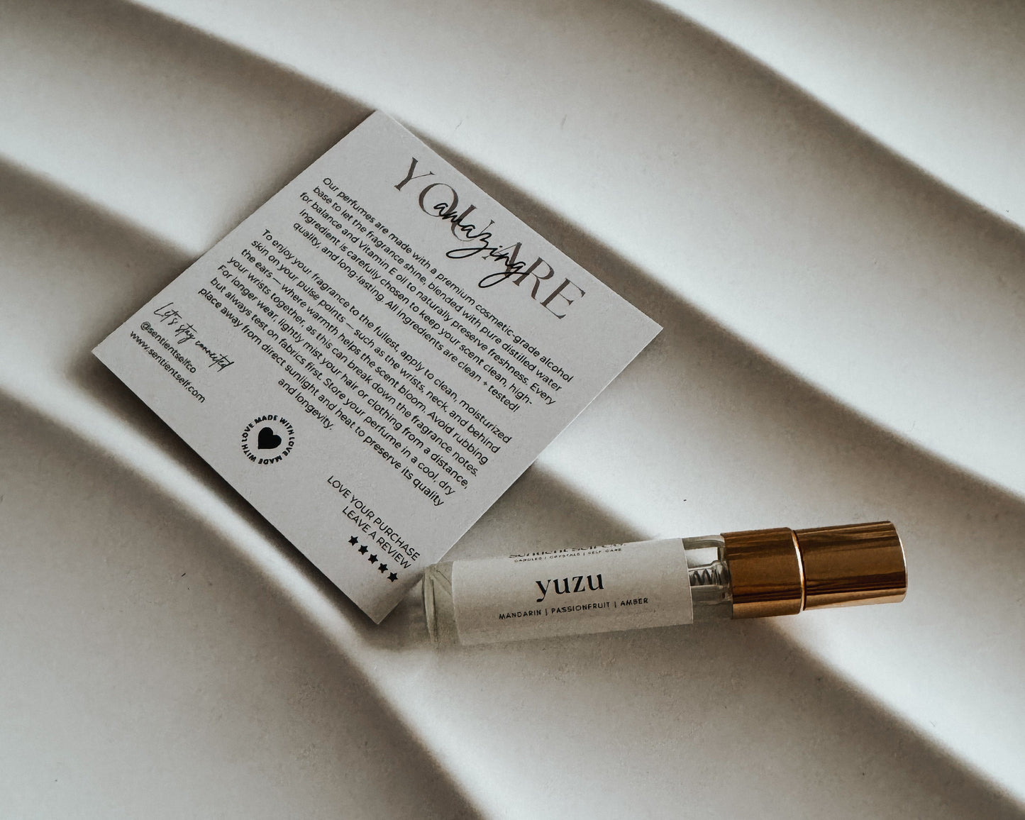 Yuzu perfume bottle and card on a textured surface